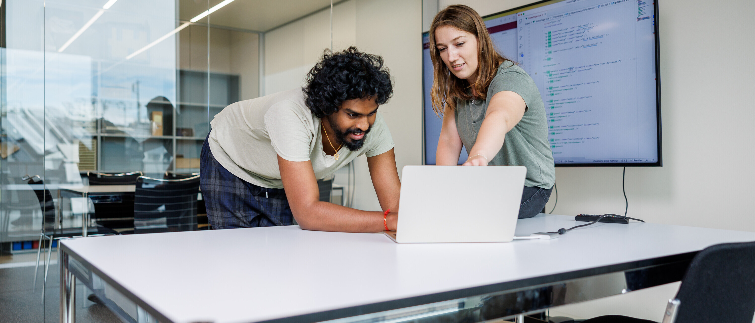 Ein Mann und eine Frau schauen in einen Laptop (Symbolbild für Master Computer Science MSE)
