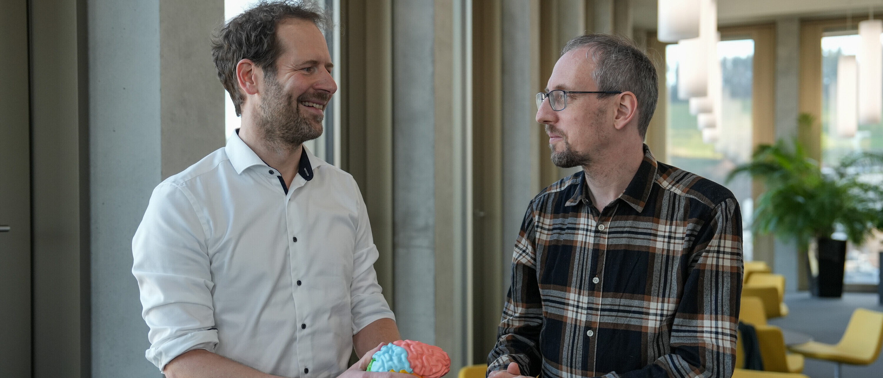 Zwei Forscher der OST stehen an einem Tisch und diskutieren über neue Diagnose- und Therapie-Möglichkeiten für Tinnitus.