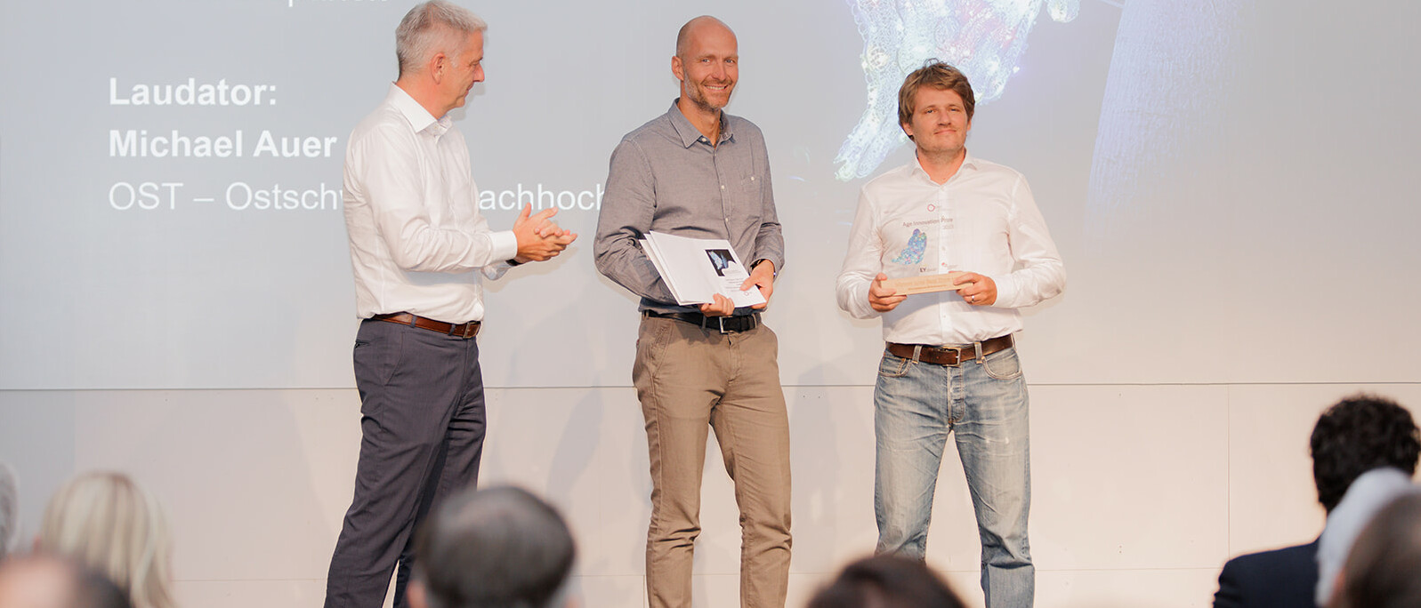 Age Innovation Preis 2023: Markus Windolf (rechts), CEO BIOS Medical AG, und Patrick Stepanek (mitte), COO BIOS Medical AG, erhalten den Preis für das beste Start-up (HIPbeacon) von Michael Auer, Präsident des Hochschulrates der OST – Ostschweizer Fachhochschule.