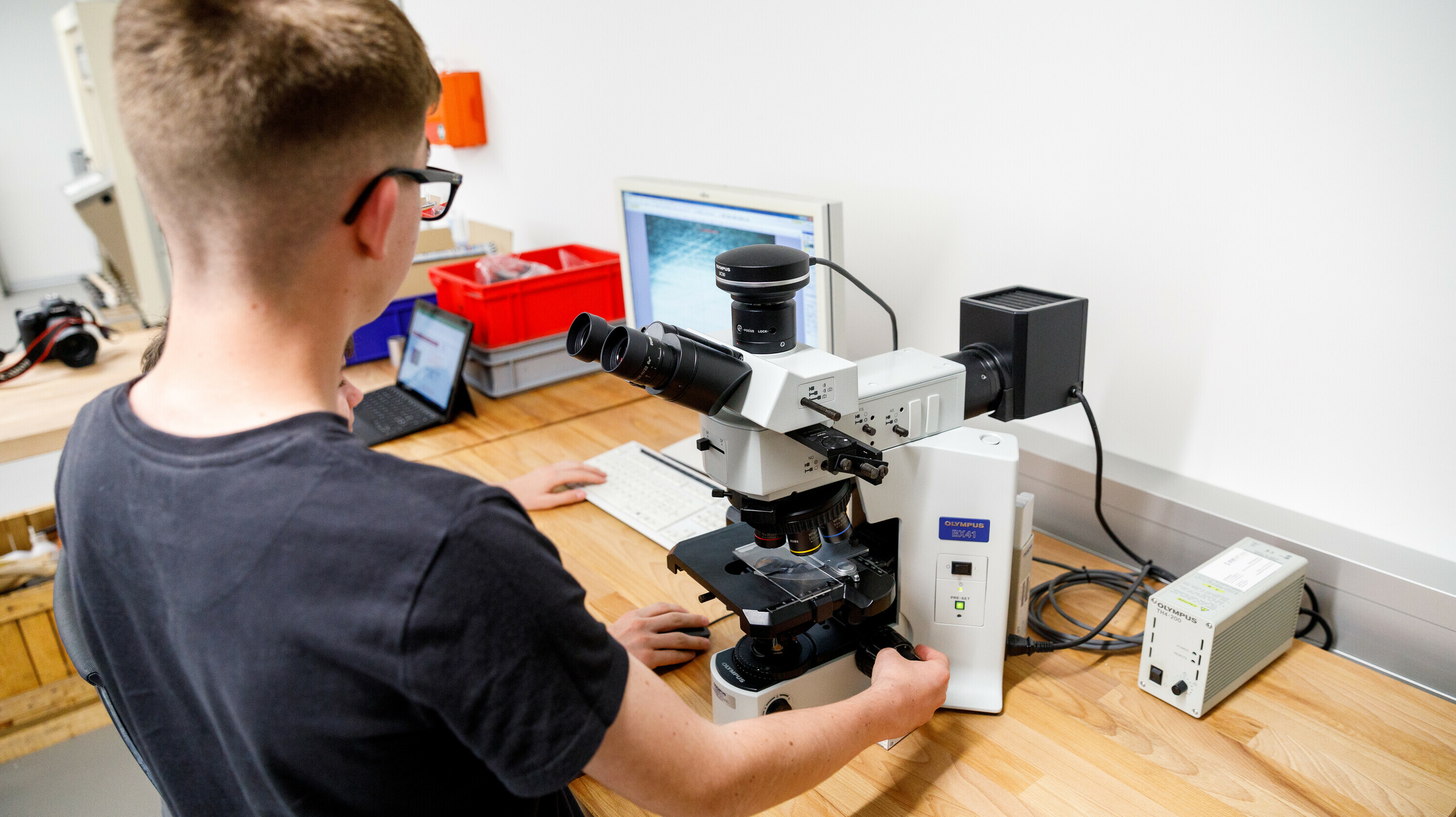 Jugendlicher arbeitet an Mikroskop im OSTLAB