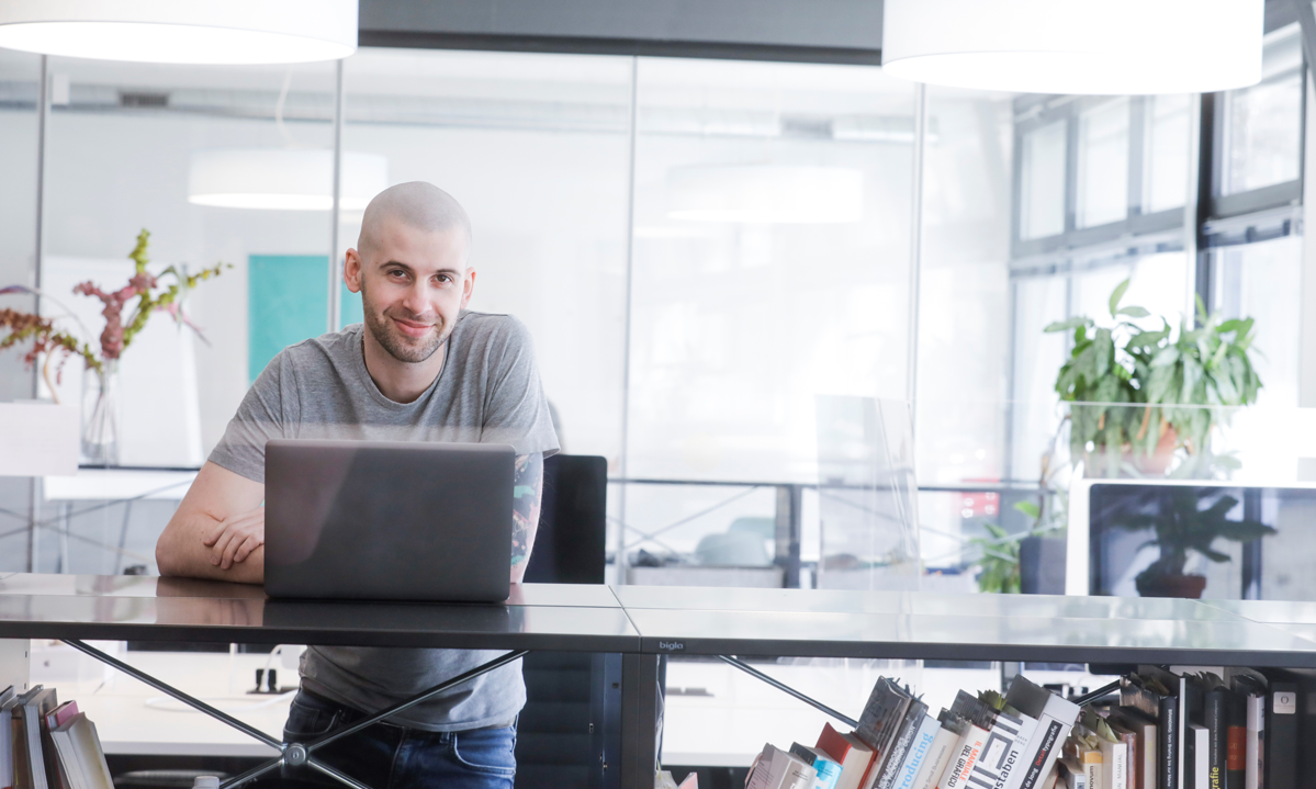 Informatiker vor einem Laptop in Büroumgebung