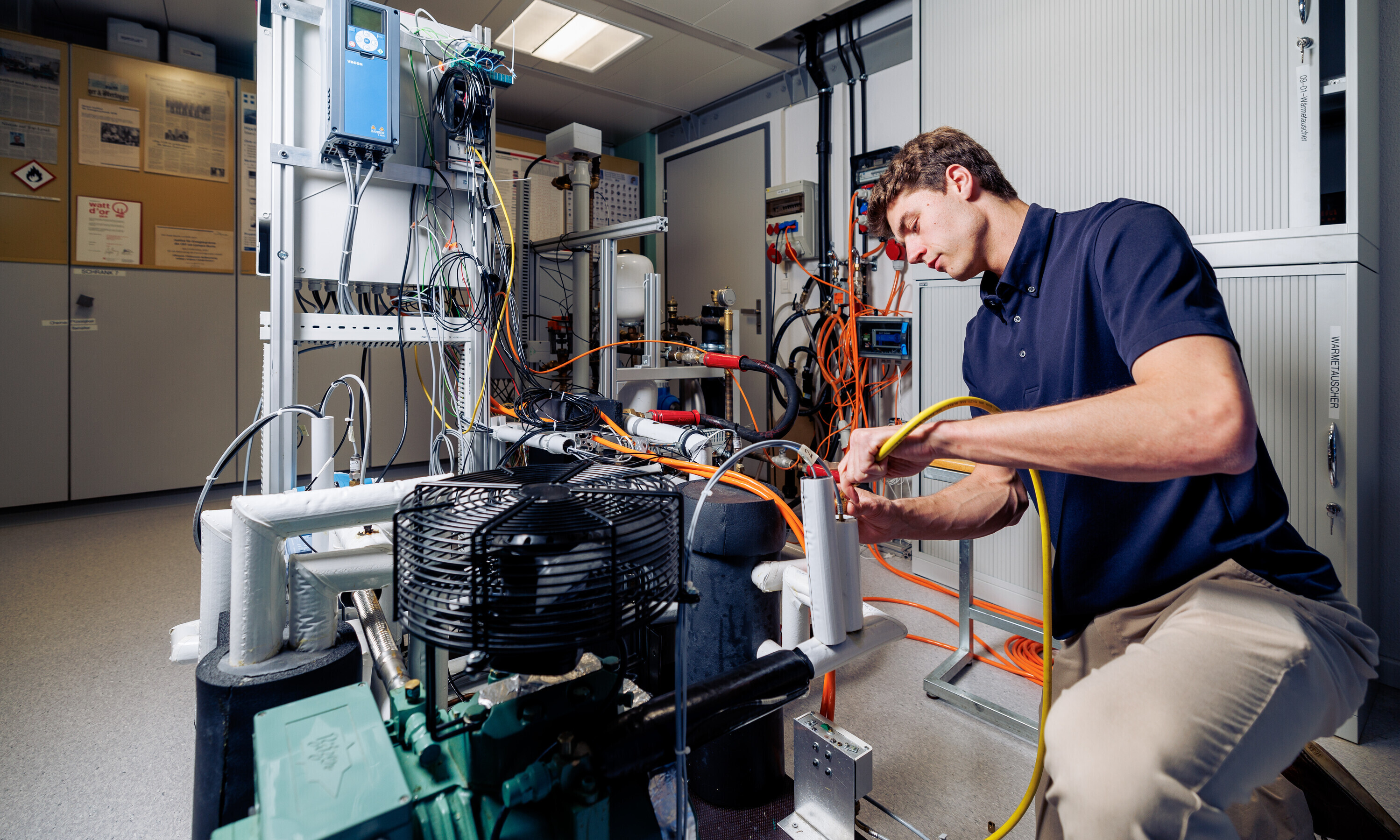 Ein Mitarbeitender der OST baut eine industrielle Wärmepumpe für das IES Institut für Energiesysteme. 