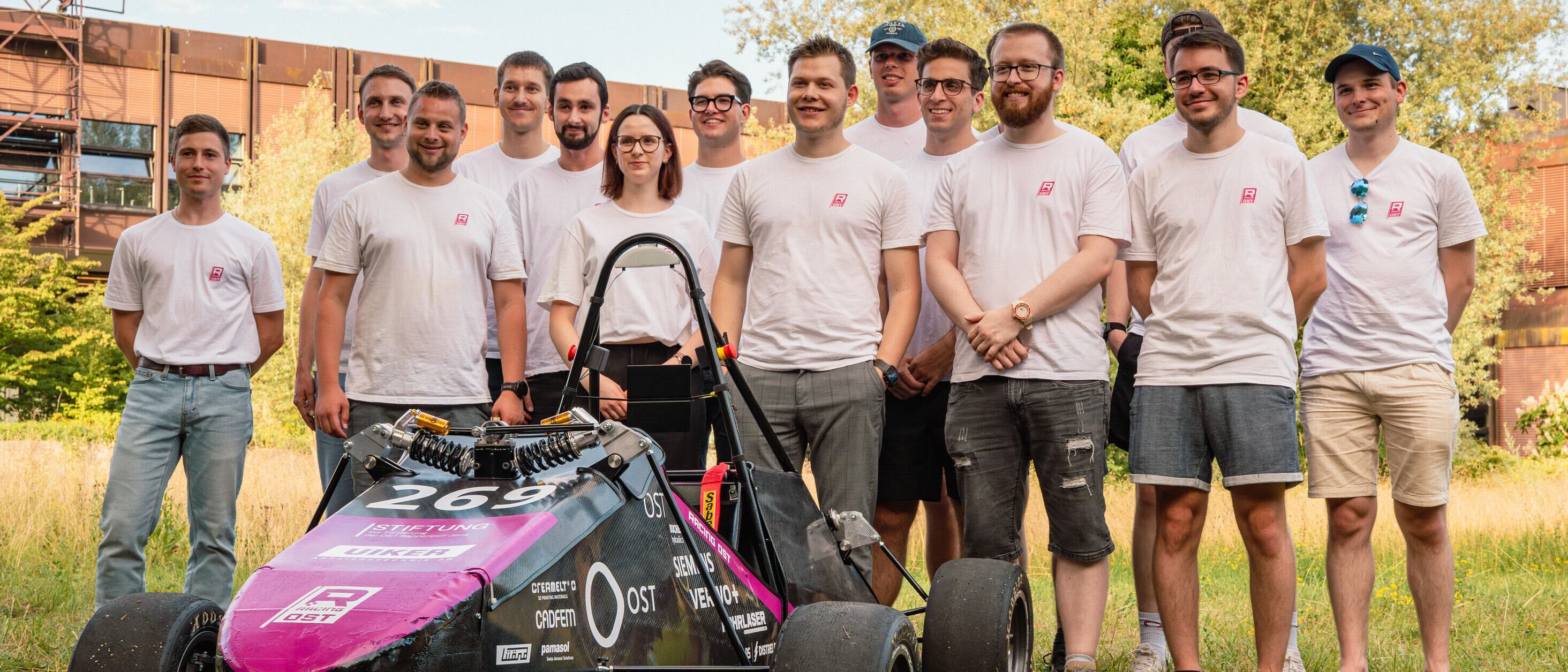 Studierendenteam vor ihrem selbst entwickelten Rennauto.