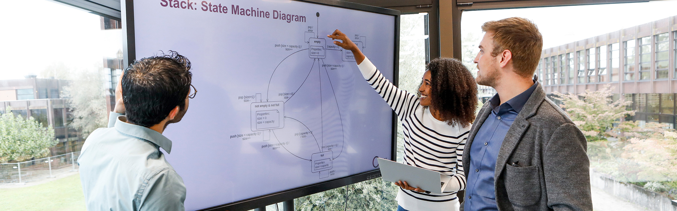 Studierende des Bachelor Informatik vor Monitor mit Machine Diagram