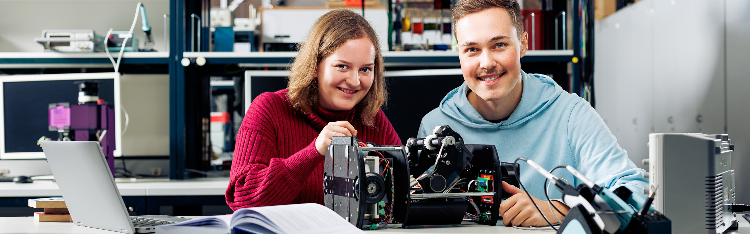 Zwei Bachelorstudierende beschäftigen sich im Labor mit Elektrotechnik.