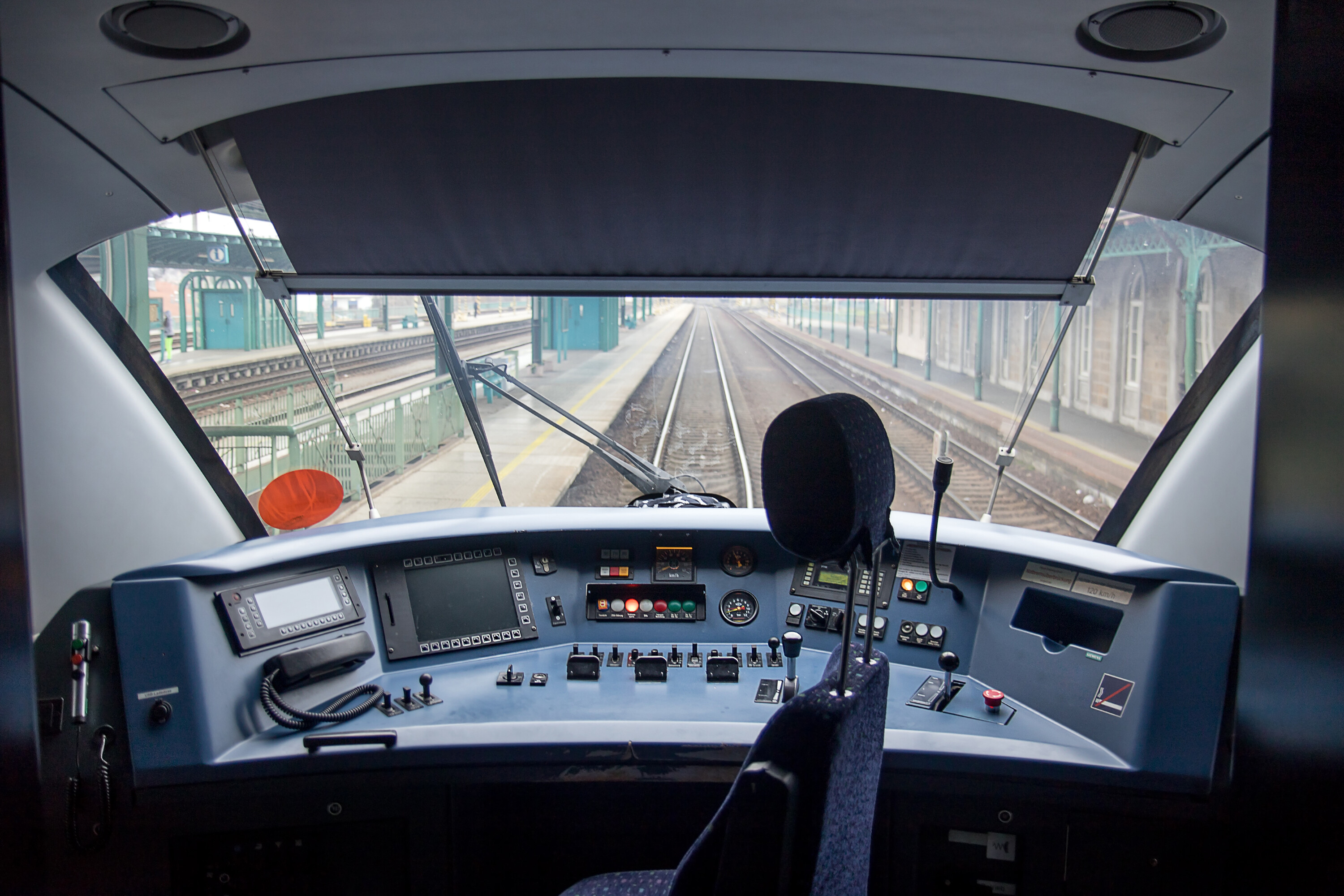 View through the windshield in the driver's cabin of a train in a station. Cockpit modern train.