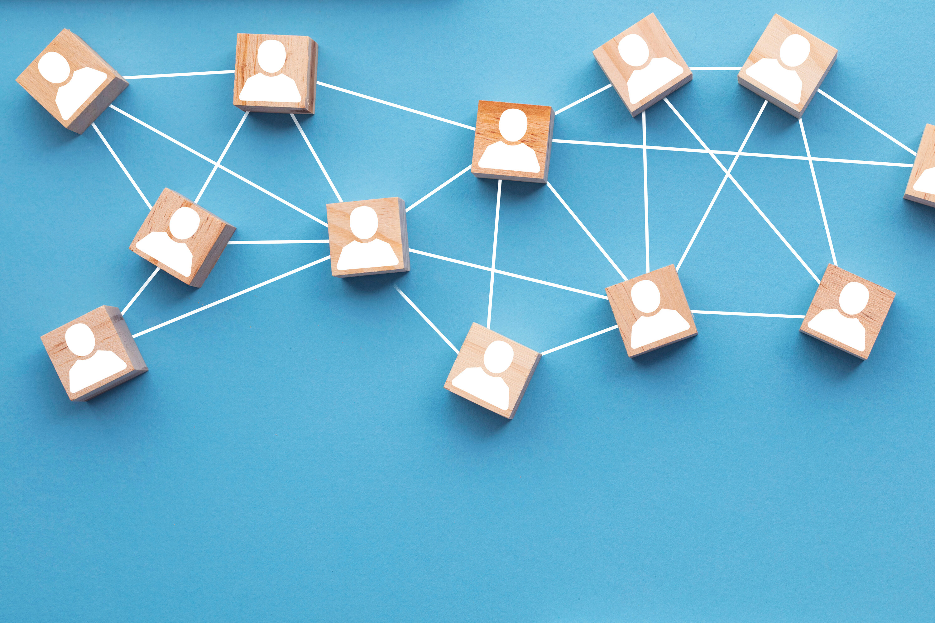Wooden blocks connected together on a blue background. Teamwork