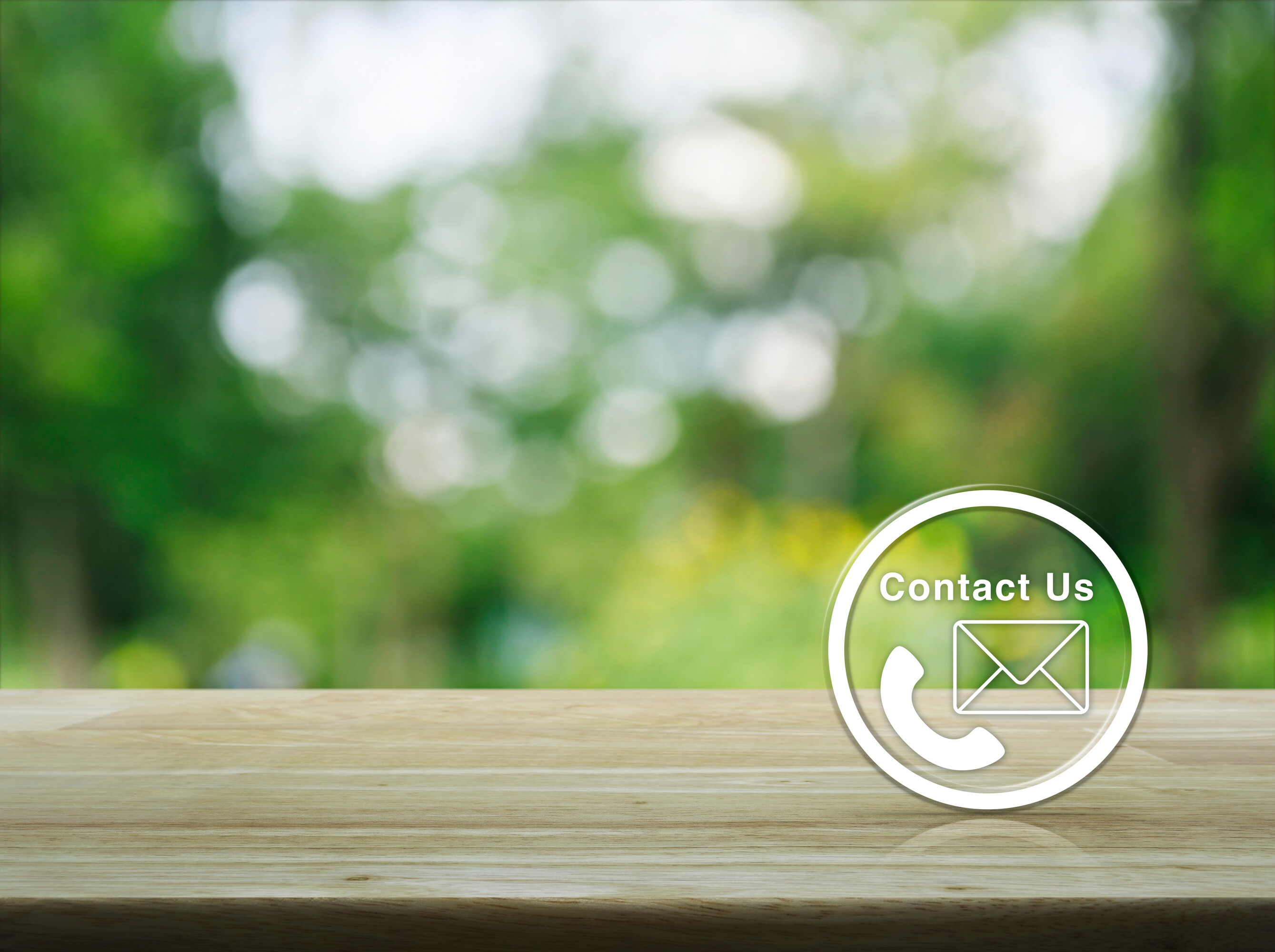 Telephone and mail icon button on wooden table over blur green t