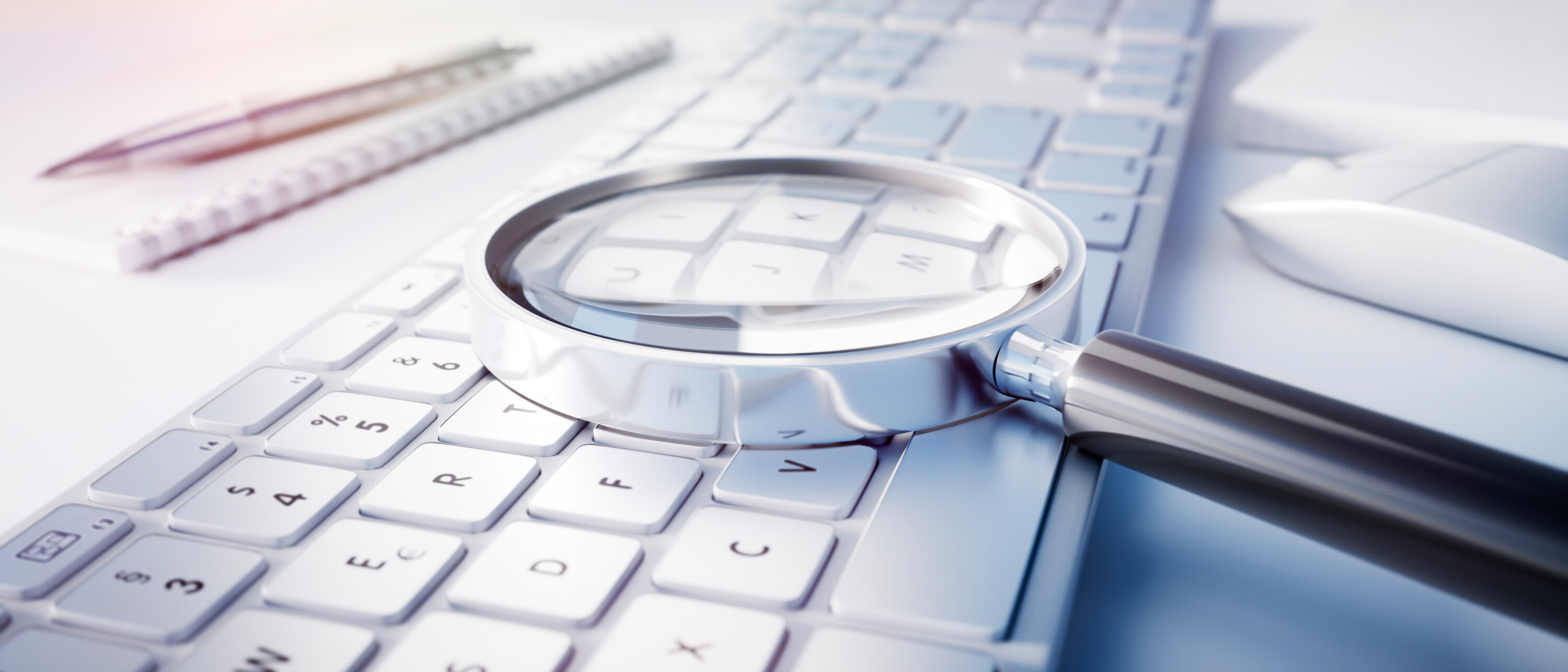 Magnifying glass on computer keyboard - search technology concep